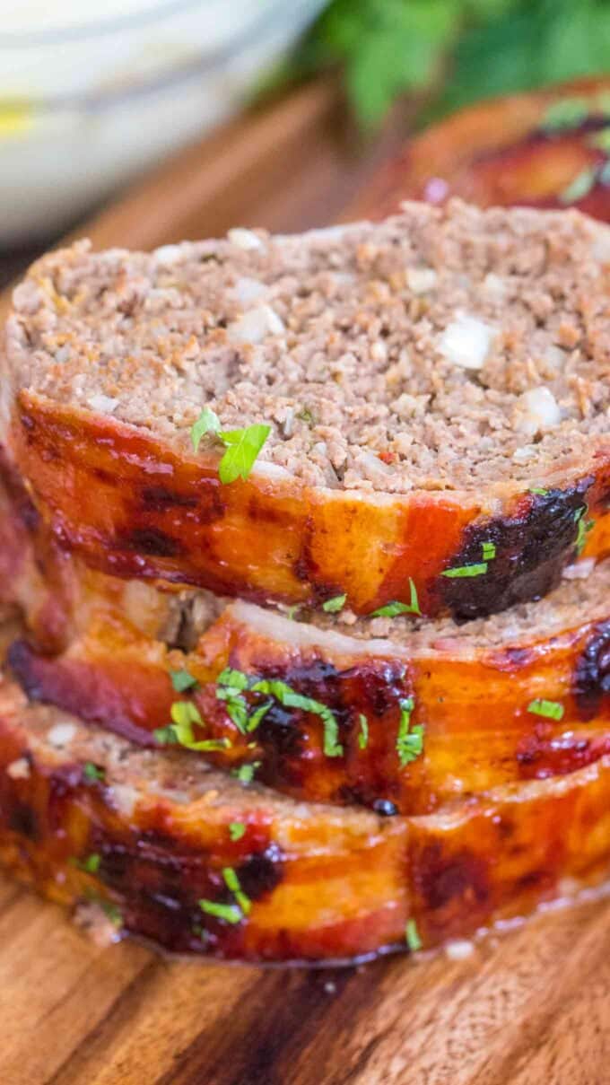 Homemade bacon wrapped meatloaf with glaze slices stacked on top of each other