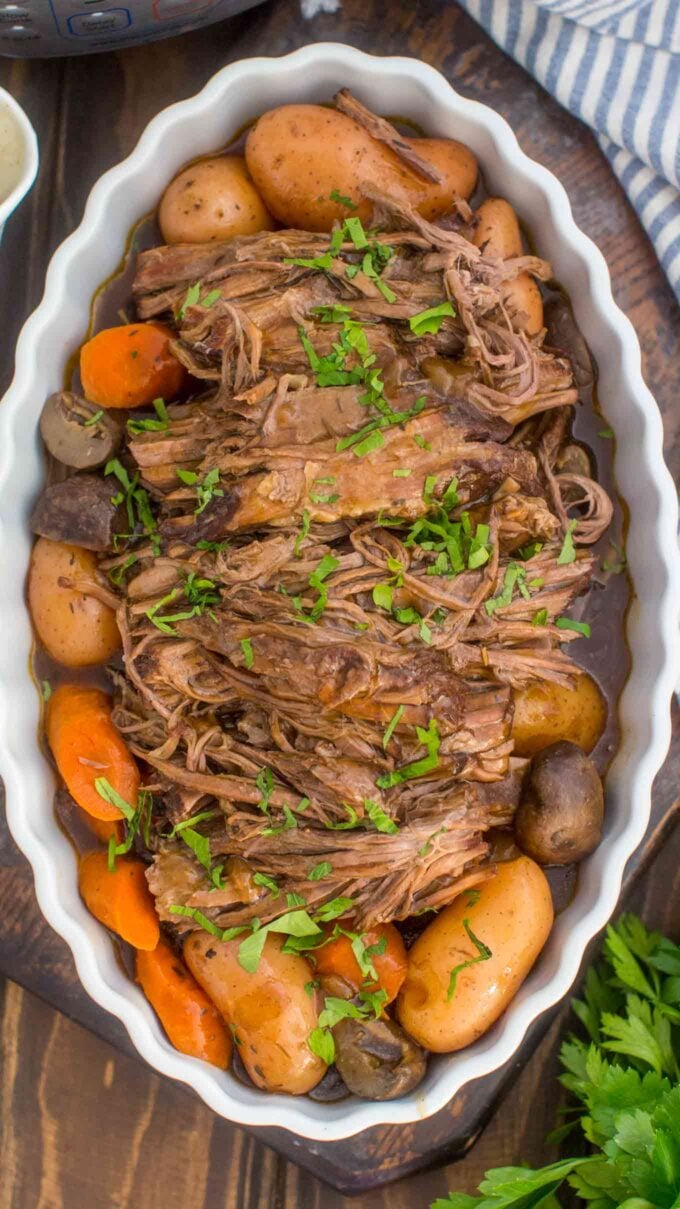 shredded tender pot pot roast with potatoes and garnished with parsley