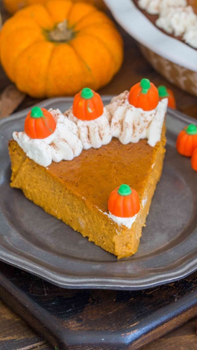 a slice crustless pumpkin pie topped with whipped cream on a silver plate