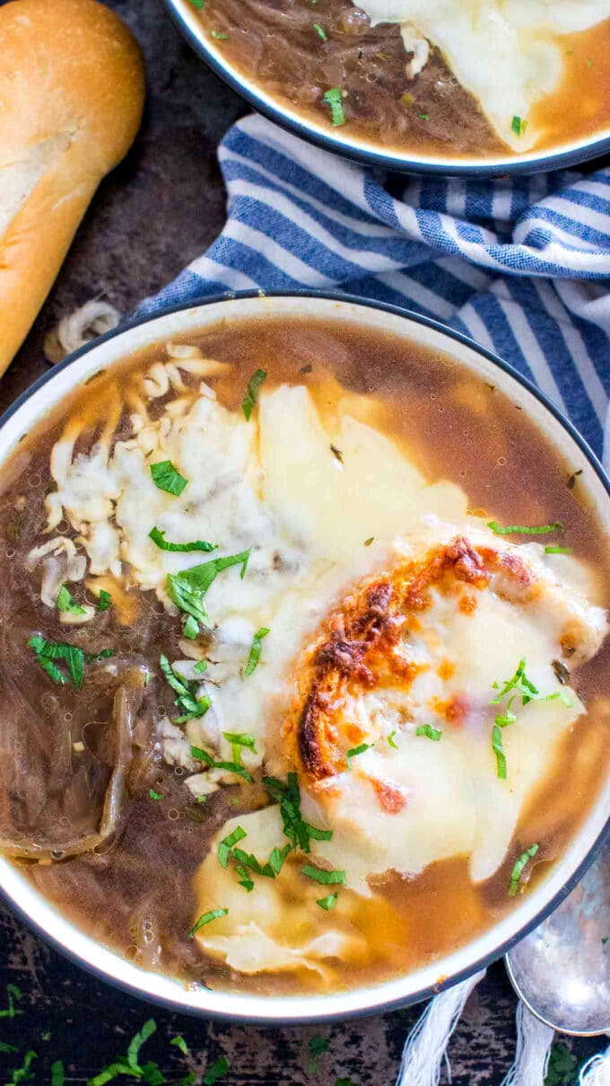 Bowl of Instant Pot french onion soup topped with melted cheese and a slice of bread