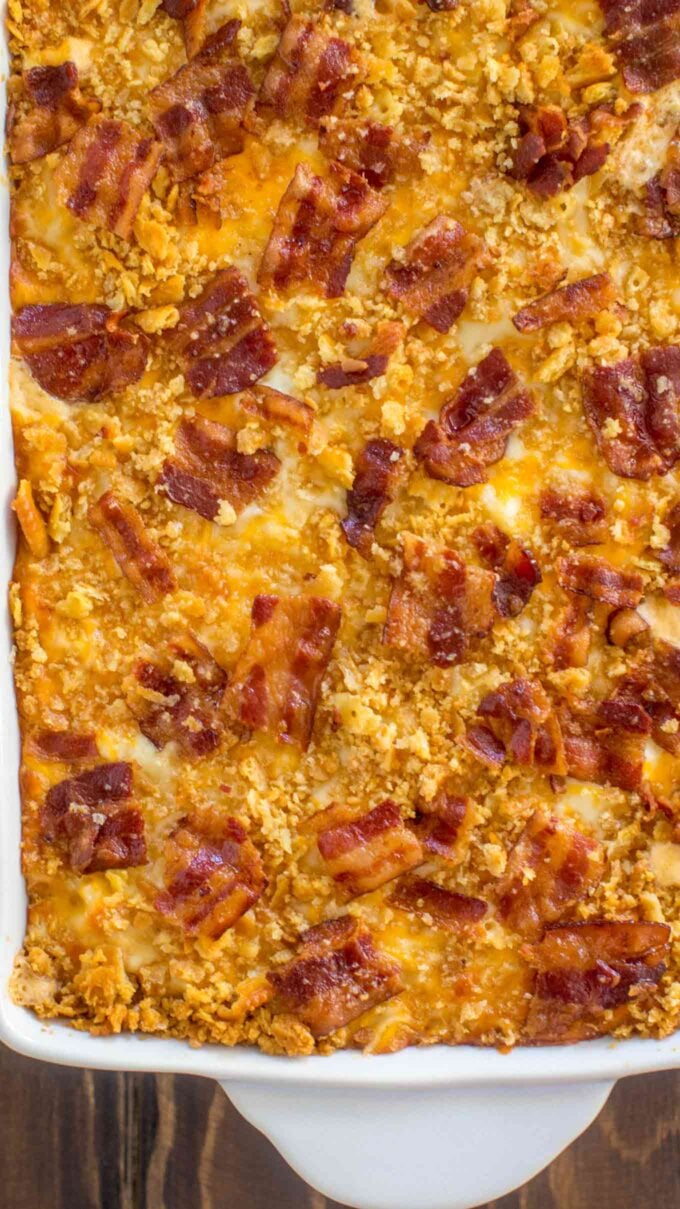 Close-up mac and cheese casserole with bacon in a white baking dish.