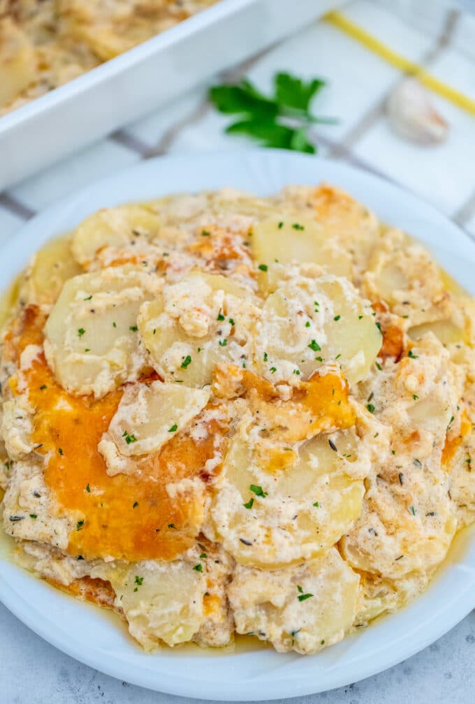 Scalloped potatoes with cream on a white serving plate