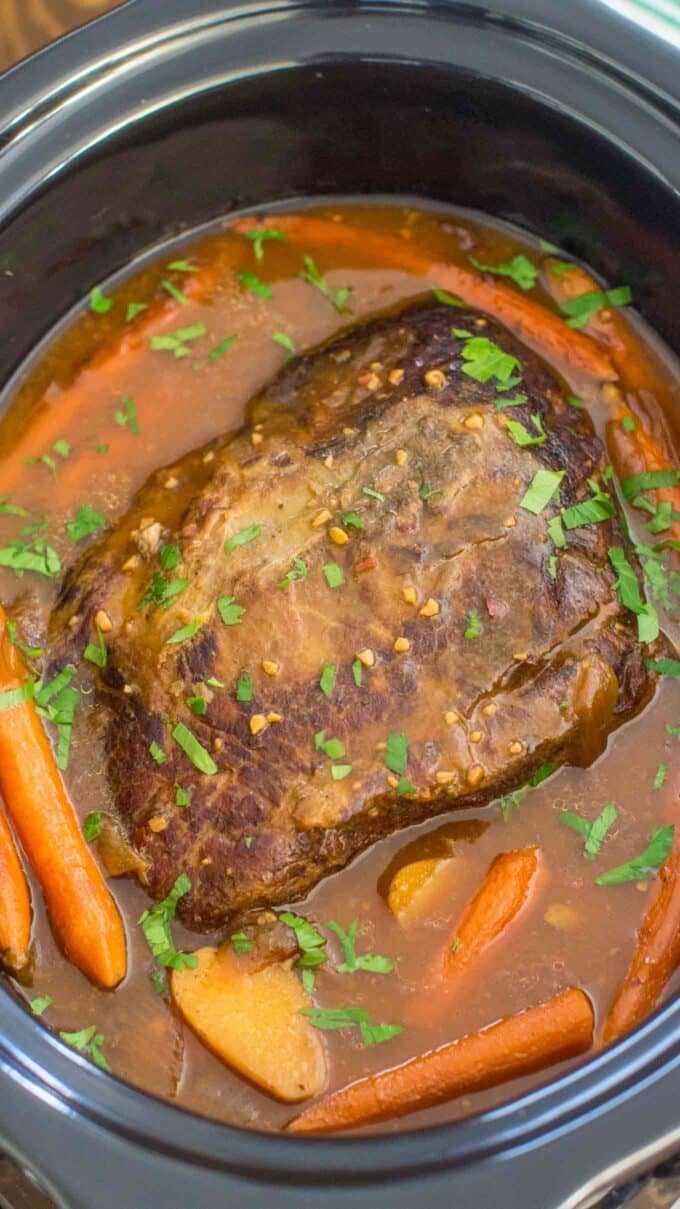 overhead shot of slow cooker London broil garnished with chopped parsley