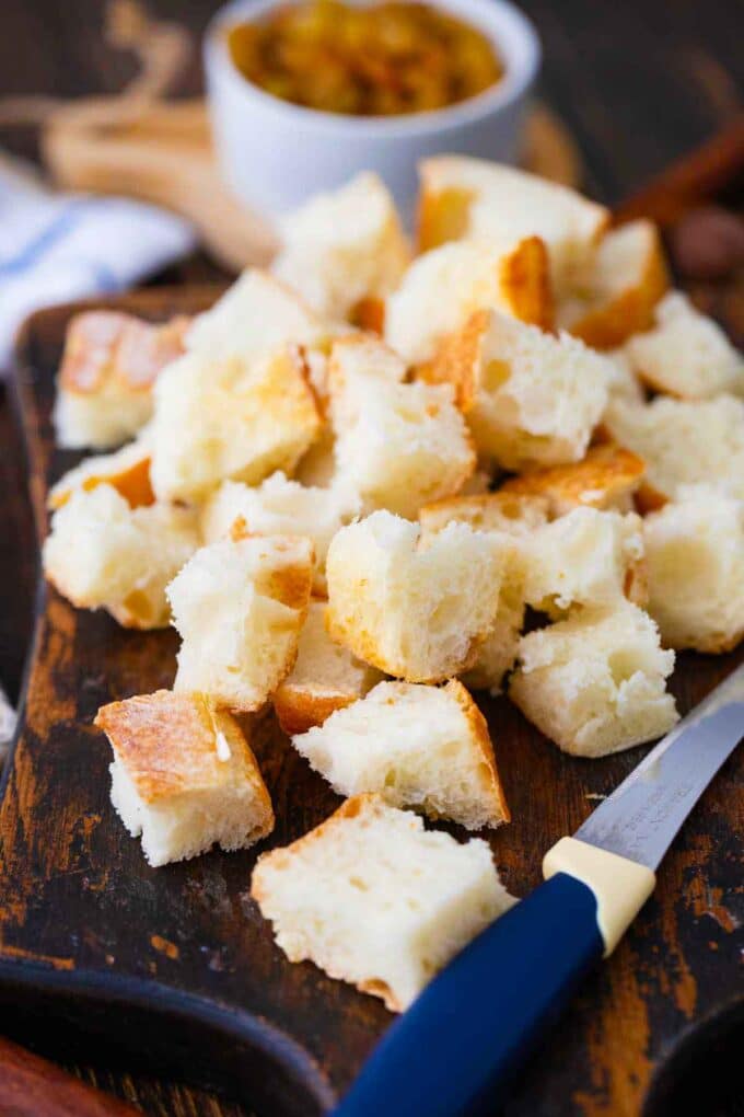 bread cubes on a cutting board with a knife next to them