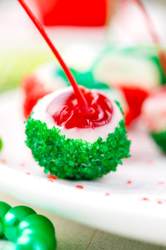 Homemade boozy Christmas drunken cherry dipped in white chocolate and green sanding sugar.
