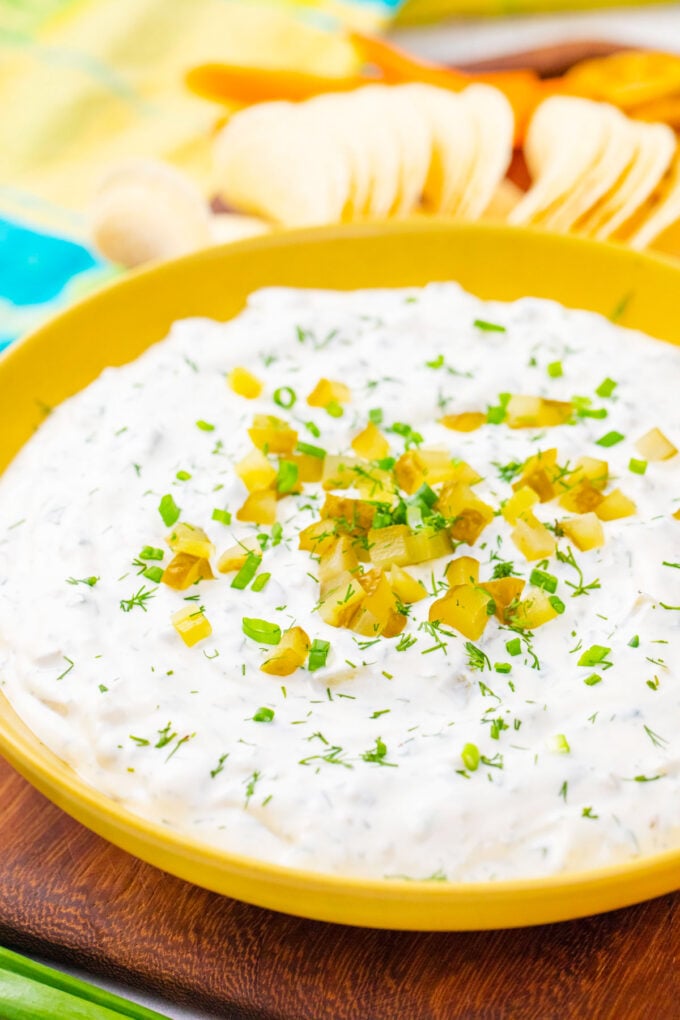A bowl of dill pickle dip topped with diced pickles.