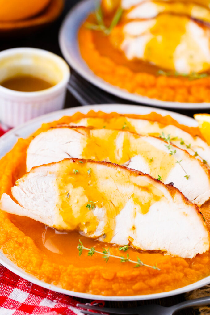Sliced oven roasted turkey breast with honey orange sauce over sweet mashed potatoes.