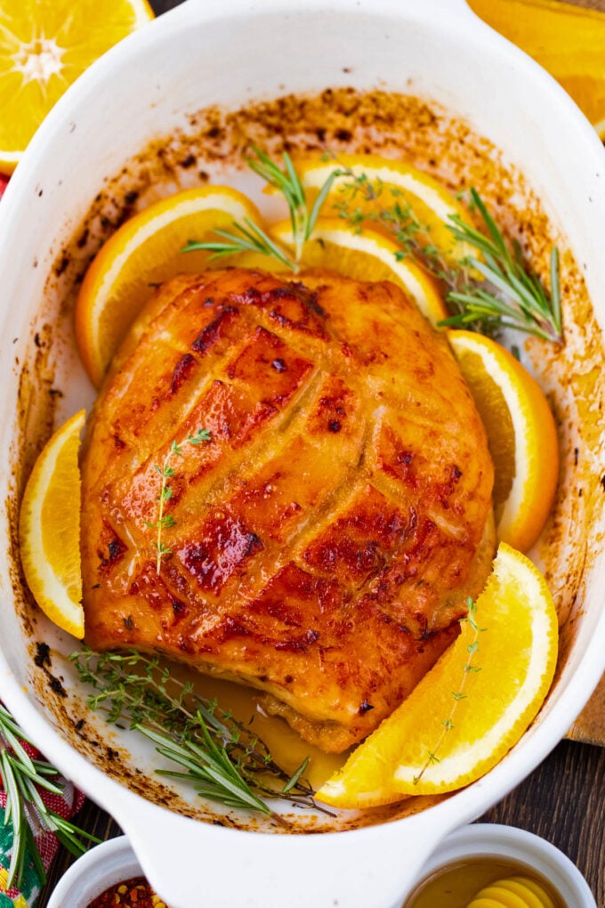 Overhead shot of oven roasted turkey breast with oranges and herbs.