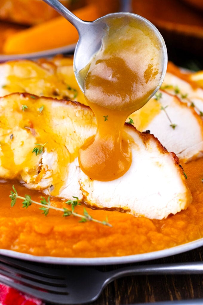 Drizzling honey orange sauce over oven roasted turkey breast.