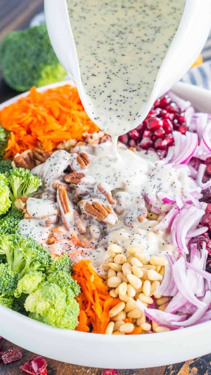 pouring homemade poppy seed dressing over Broccoli Salad