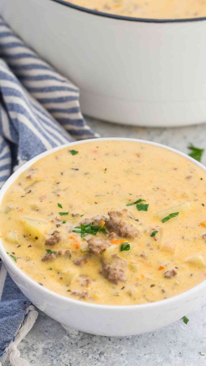 Cheeseburger soup with ground beef in a white bowl