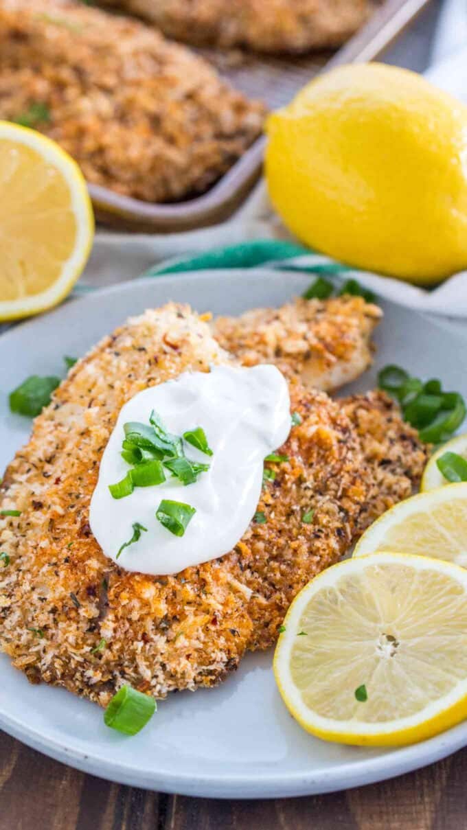 Image of oven baked tilapia topped garnished with sour cream and lemon.