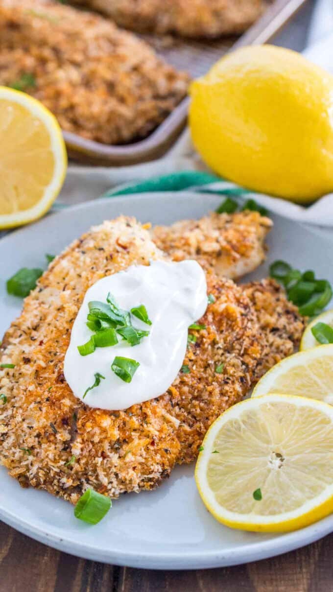 Image of oven baked tilapia topped garnished with sour cream and lemon. 