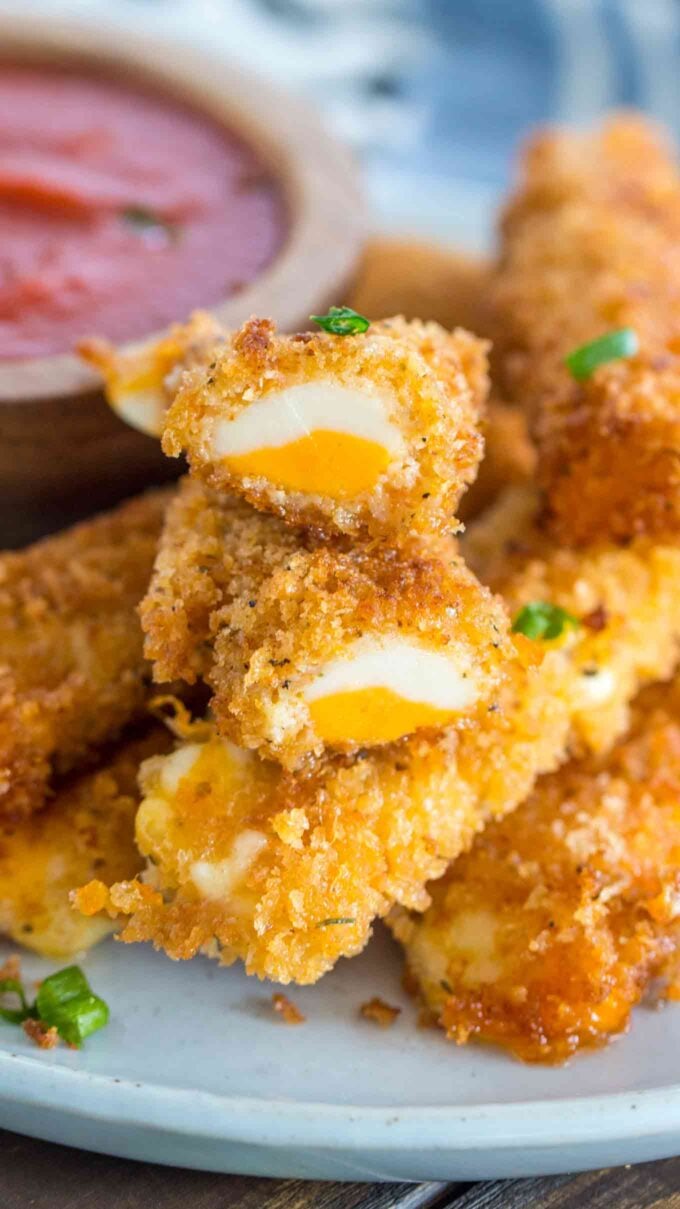 Fried cheese sticks on a white plate. 