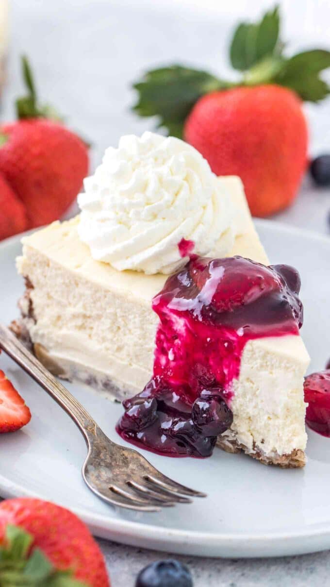 Image of a slice of keto cheesecake with whipped cream.