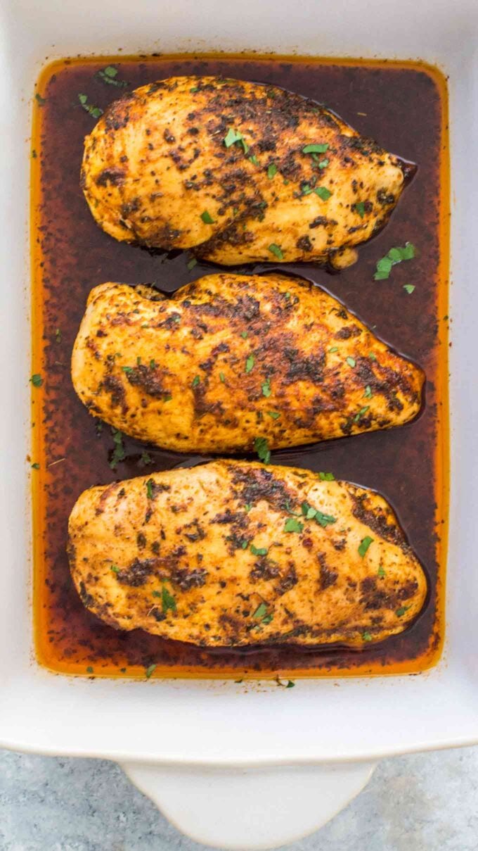 Three baked chicken breasts in a baking pan