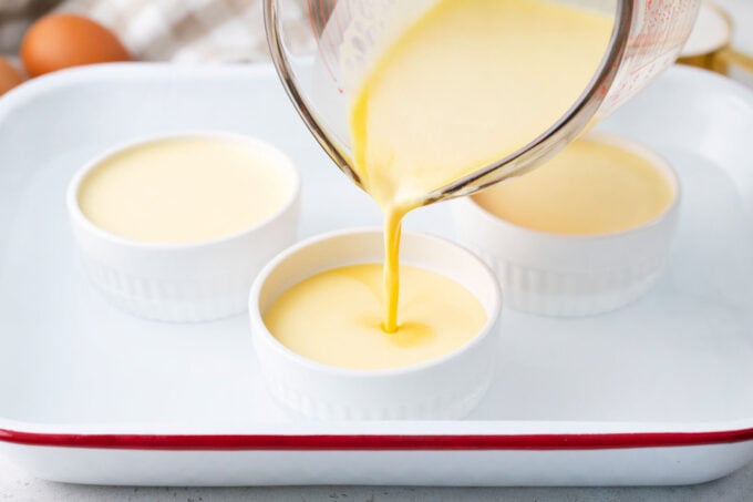 Pouring creme brulee custard into ramekins.