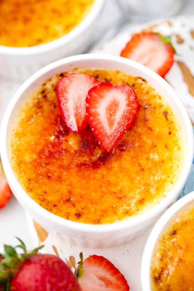 white chocolate creme brulee topped with sliced strawberries