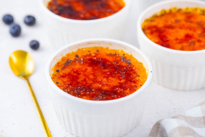 Ramekins with creme brulee and caramelized, glossy top.