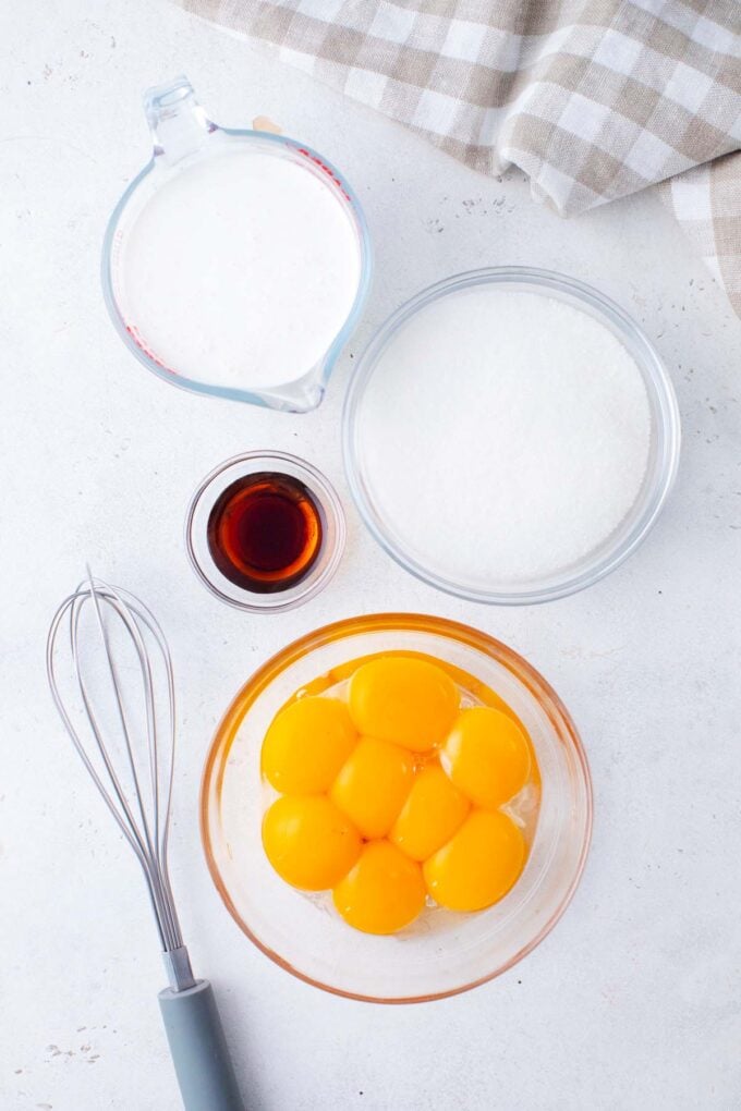 Overhead shot of creme brulee ingredients in bowls on a table.