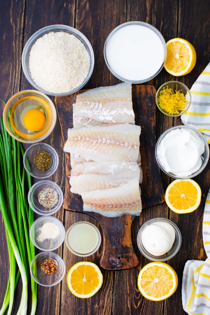 Overhead shot of crispy oven baked tilapia ingredients arranged on a wooden table.