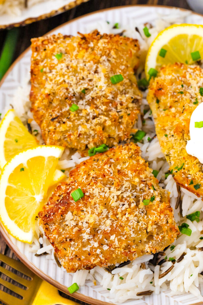 Overhead shot of crispy oven baked tilapia fillets over wild rice.