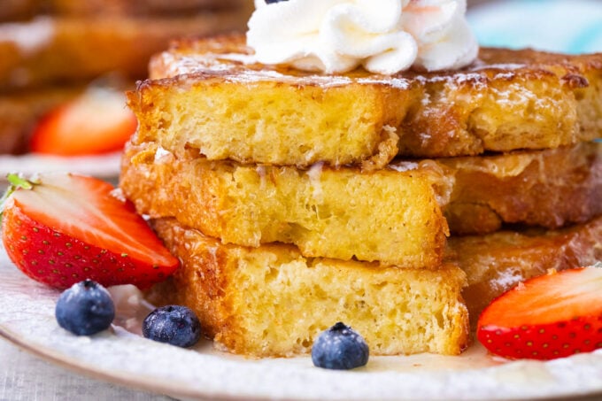 Tender brioche French toast topped with whipped cream.