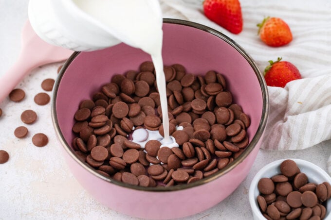 Pouring hot cream over chocolate chips.