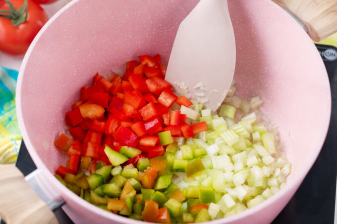 Sautéing bell peppers, onion, garlic, and celery.