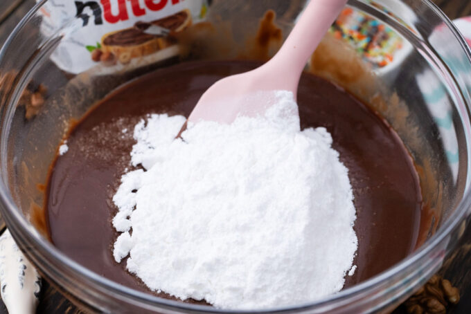 Adding powdered sugar to Nutella fudge.