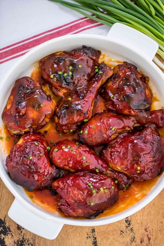 Image of baked BBQ chicken on a white baking dish.