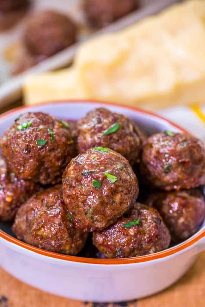 a bowl of juicy homemade meatballs sprinkled with chopped parsley