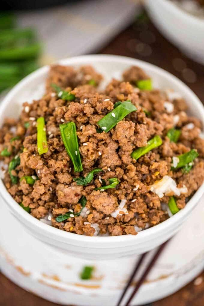 Homemade Korean ground beef garnished with chopped scallions over white rice in a bowl.