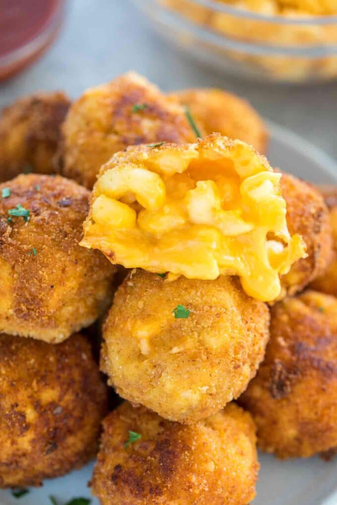 cheese oozing from a fried cheesy mac and cheese ball