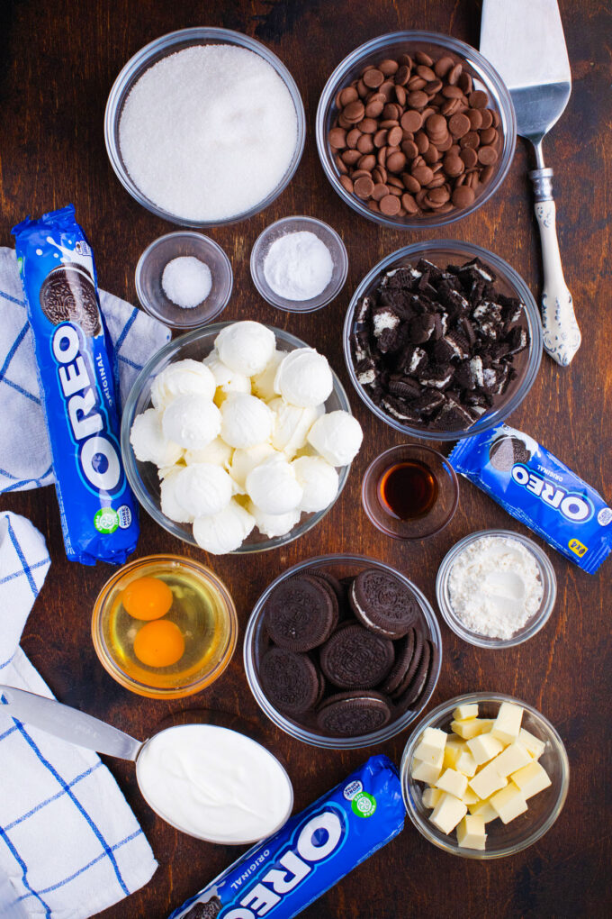 Overhead shot of Oreo cheesecake ingredients in bowls on a table.
