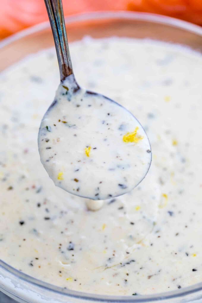 Photo of creamy lemon sauce for salmon on a silver spoon. 