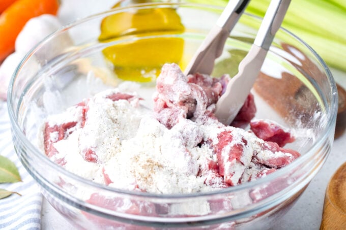 Tossing stew meat in flour.