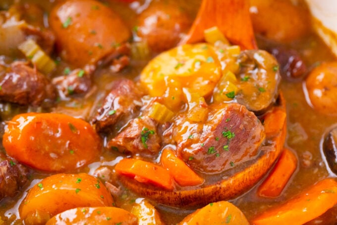Close shot of a ladle with beef stew.