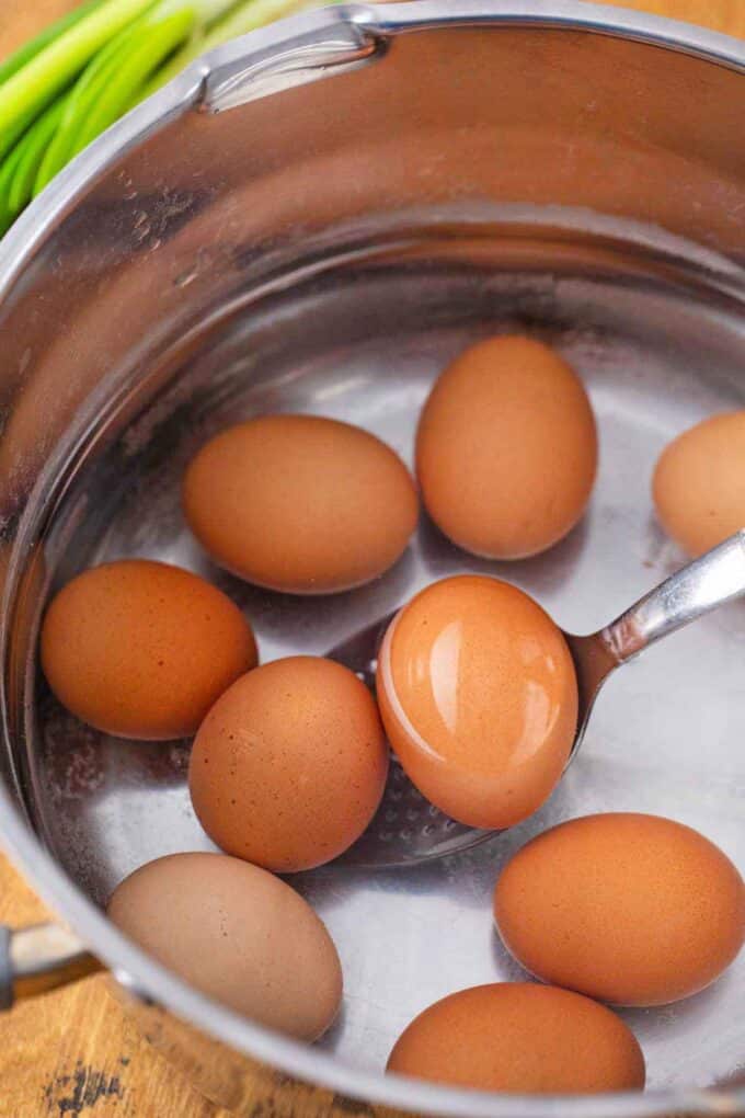 adding eggs to water in a pot