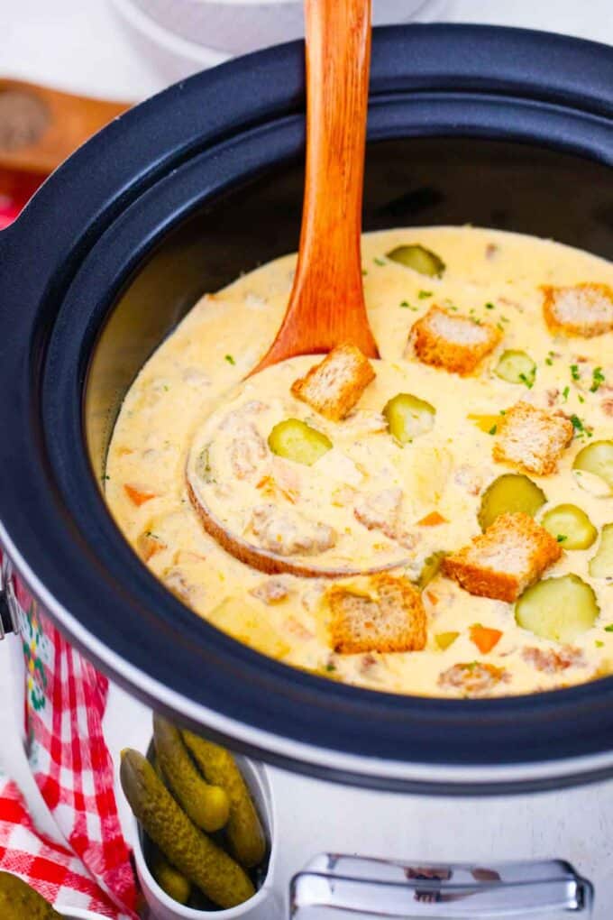 cheeseburger soup fin a crockpot with a wooden ladle in it