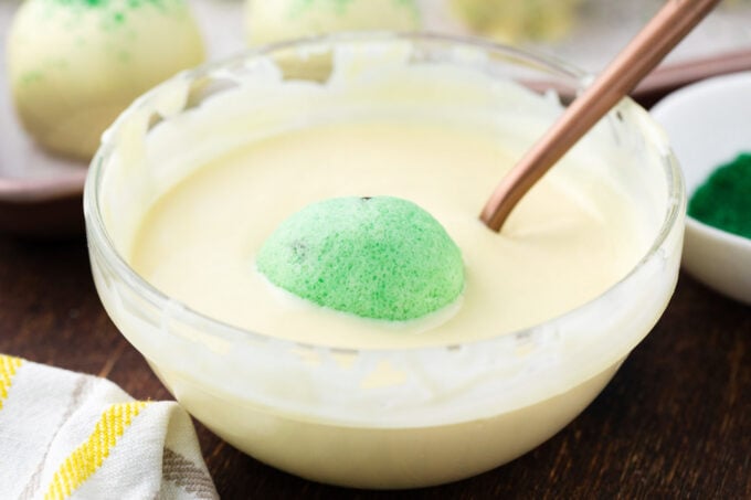 Dipping a mint chocolate chip truffle into melted white chocolate.