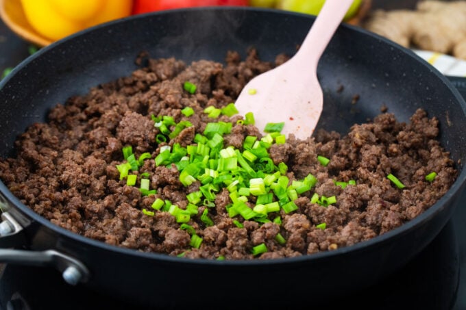 Stirring green onions into Korean ground beef.