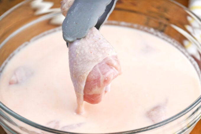 Brining chicken pieces in buttermilk.