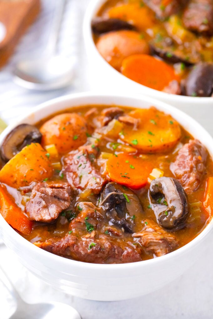 A bowl of homemade beef stew with potatoes, carrots and mushrooms.