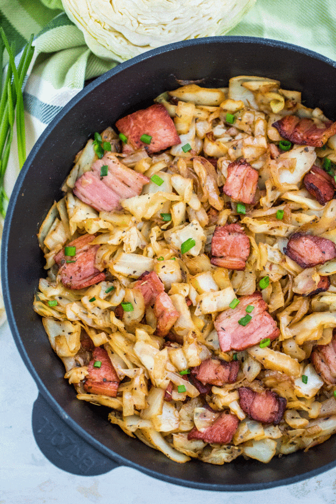 Photo of fried cabbage and bacon in a skillet.