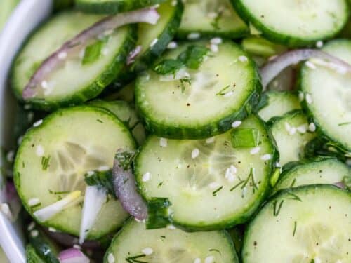 Two fresh green mini cucumbers and sliced half with three slices