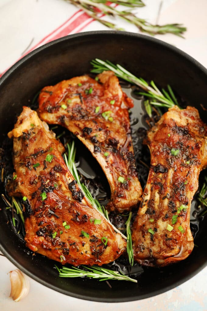 Image of cooked lamb ribs with herbs and rosemary.