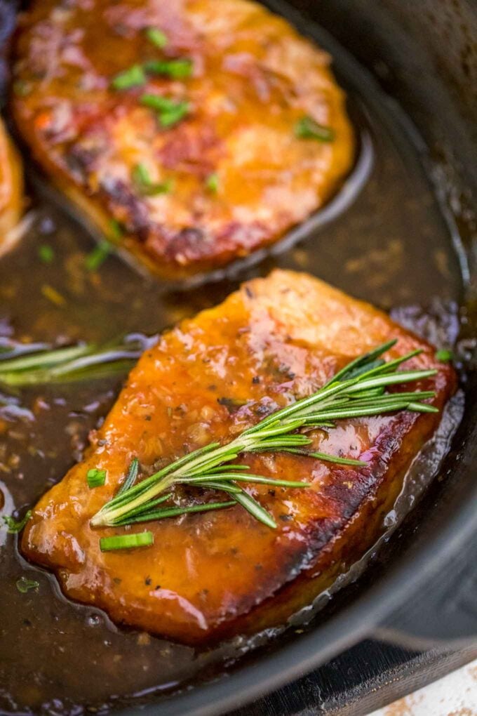 Image of pork chops in honey garlic sauce and topped with rosemary.