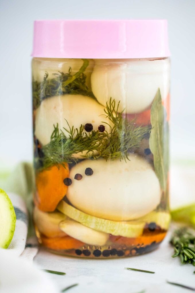 Pickled eggs with rosemary, spices and sliced carrots in a jar