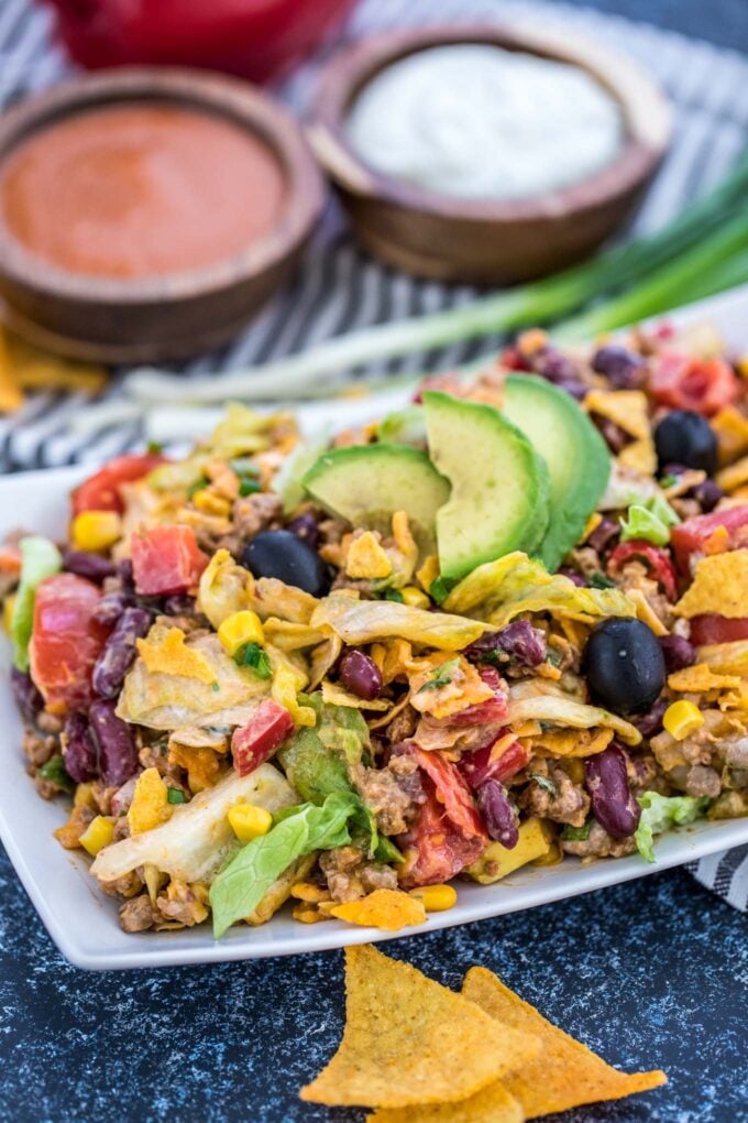 Close-up of homemade salad made with taco seasoning and chips on a white plate.